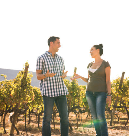 Couple spending time together in nature on a beautiful sunny day in the vineyards wearing casual clothingの写真素材