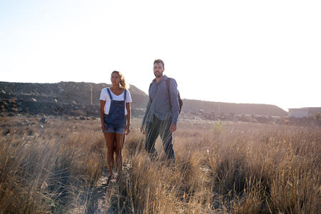 Man and woman looking at the view as they stand on a grassy plainの写真素材