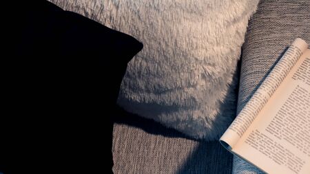 Book on gray armchair. Sunlight illuminating the scene.の写真素材