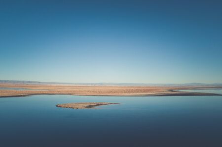 Quietly situated sea with a view of distant mountains on the horizonの写真素材
