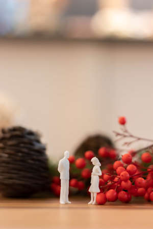 White male and female toy figures talking with christmas backgroundの写真素材