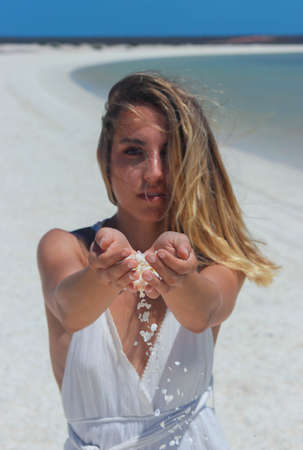 woman with beautiful hands holding shells on paradisiacal beach in australia