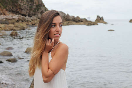 woman in white dress on the sea with cloudy skyの写真素材