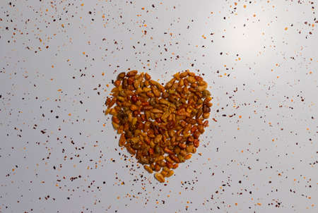 Heart shape made with red cayenne on a white background