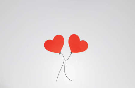 Two heart-shaped balloons joined by a string for Valentines Dayの写真素材