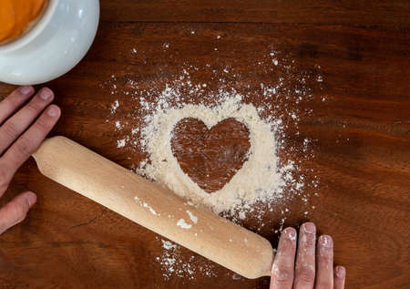 Heart shape with flour on rustic wooden countertop backgroundの写真素材
