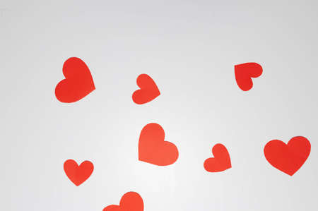 Red hearts of different sizes on a white backgroundの写真素材