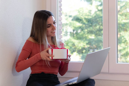 Woman making a video call and surprising her relatives with a gift