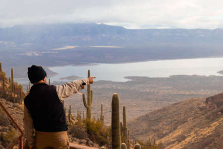 Man pointing at the Thedore Roosevelt Lake from the tonto natural monumentの写真素材
