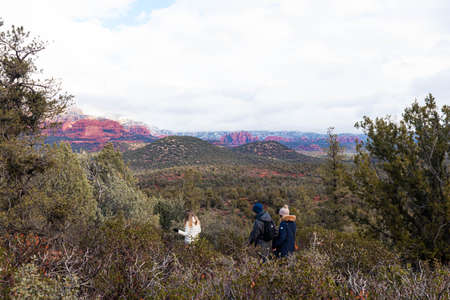 Three young people hiking through the red rock state parkの写真素材