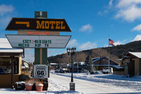 Vintage sign of motel in village on Route 66 in winter surrounded by snow