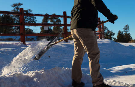 Close up of man taking snow off the road in the middle of winterの写真素材