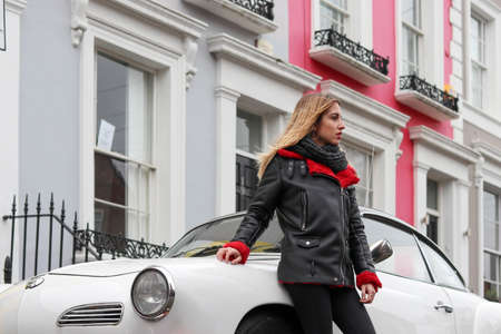 beautiful girl sitting in vintage car in londonの写真素材
