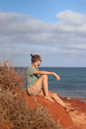 Profile portrait of young man on red sand beachの写真素材