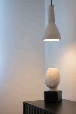 Detail of decorative figure in the shape of a head illuminated by cement lampの写真素材
