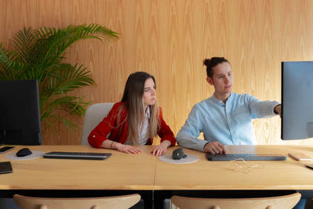 Two young workers working together in modern officeの写真素材