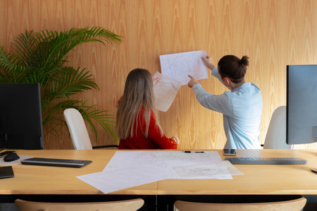 Back workers with architectural sketches and technical plansの写真素材