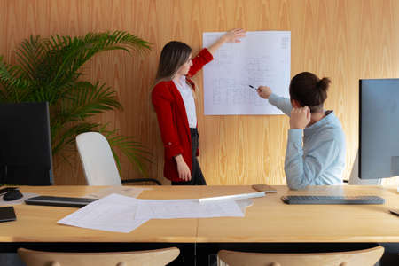 Architects showing blueprints with new projects at officeの写真素材