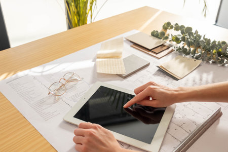 Woman touching tablet touch screen with background interior design moodboardの写真素材