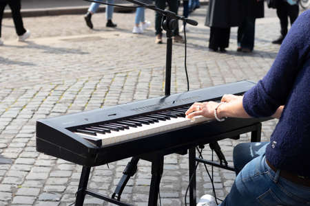 Unrecognizable young musician playing the piano and singing in the city streetの写真素材