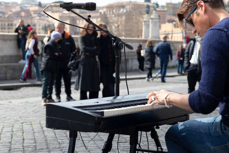 Rome, Italy - March 17th, 2022. Portrait of young musician playing the piano and singing in the street in Romeのeditorial素材