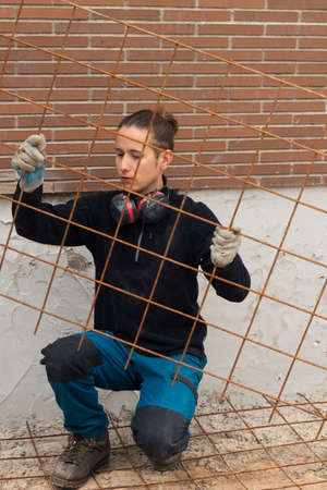 Man working in the construction with a wire mesh to make a concrete screedの写真素材