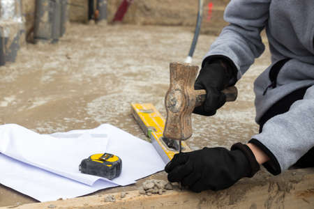 Hands of unrecognizable woman nailing with a hammer and different tools around