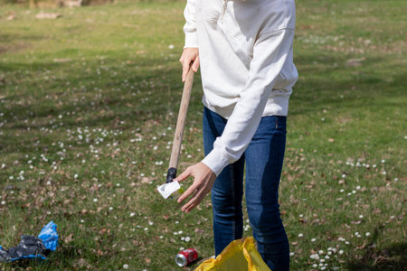 Unrecognizable man collecting plastic from the ground in a volunteer collectionの写真素材