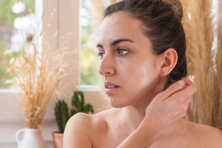 Young woman looking at the side half-naked out of the shower with bright face