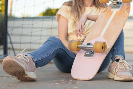 unrecognizable portrait of a teenage girl sitting on the floor resting after a skate sessionの写真素材