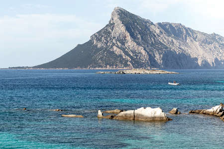 Beautiful landscape of mediterranean sea with mountain in the horizon and a boat in the middle of the oceanの写真素材