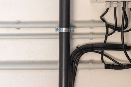 Close up view of electrical and plumbing instalation on white wall
