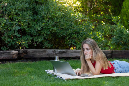 Half body view of young woman working as a freelancer around the world sorrounded by natureの写真素材
