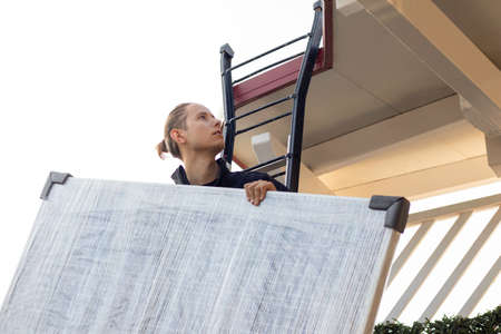 Young man worker installing a solar panel for eco energy and avoid global warmingの写真素材