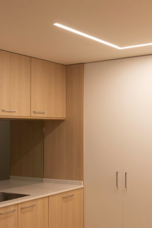 Vertical view of modern minimal wood and white kitchen illuminatedの写真素材