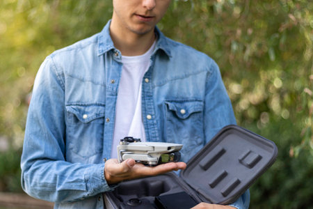 Close-up view of a quadricopter drone in selective focus view next to its travel briefcase in the...