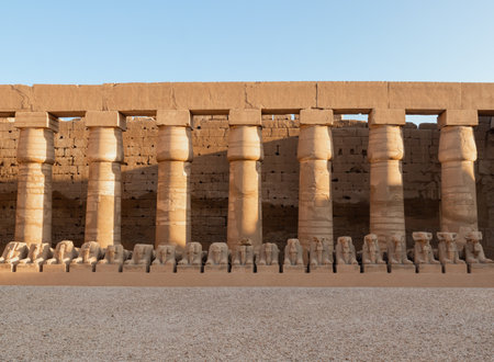 Columns and statues in the Temple of Karnak in Luxor, Egypt with sunset orange and gold light. Ancient and heritage temple architectureの写真素材