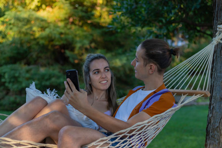 Young happy similing couple taking a picture of themselves while looking to each other as an idyllic summer loveの写真素材