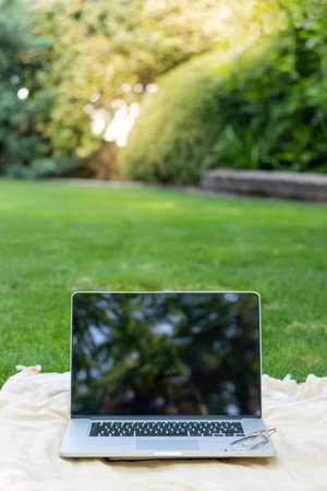 Vertical view of isolated laptop with blurred background an reflections on the screen for online job and digital nomad in the worldの写真素材