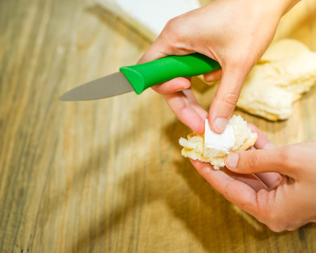 Close up top view of hands preparing snack of brie cheese with bread in the afternoonの写真素材