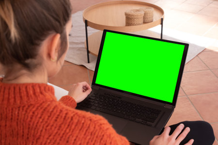 Anonymous female patient speaking with medical practitioner while having video chat on laptop during online consultation at homeの写真素材
