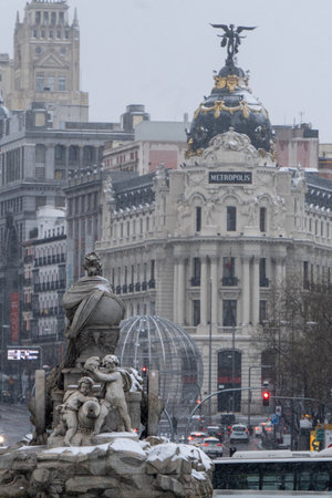 Madrid, Spain - January 2021: Metropolis building and Cibeles fountain (Fountain of Cybele) with snow due to Filomena Storm.のeditorial素材
