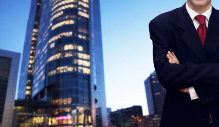 Confident businessman and bank office building in backgroundの写真素材