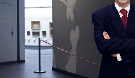 Staff man standing inside museum interior with paintingsの写真素材