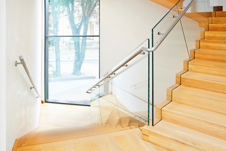 Modern architecture interior with elegant wooden stairs and glass balustradeの写真素材