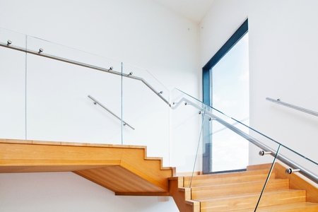 Modern architecture interior with elegant wooden stairs and glass balustradeの写真素材