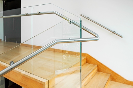 Modern architecture interior with elegant wooden stairs and glass balustradeの写真素材