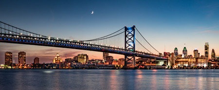 Philadelphia skyline and Benjamin Franklin Bridge at dusk as seen from Camden, New Jerseyの写真素材