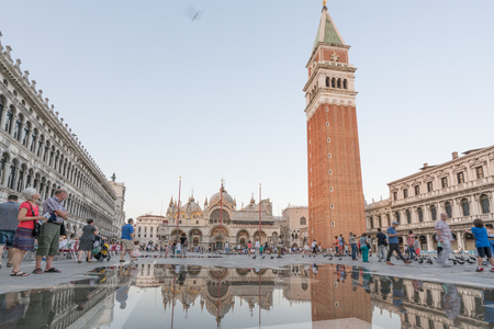 VENICE, ITALY - JULY 1, 2016: Tourists in San Marco square in front of St. Mark's Basilica in Venice, Italy as water water risesin the square.のeditorial素材