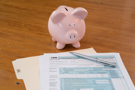 IRS Tax Form with Piggy Bank, Calculator, Pen and Glassesの写真素材